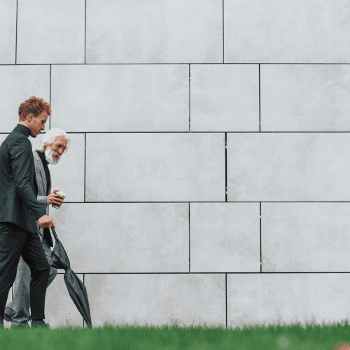 Two businessmen from different generations walking together, symbolising next-gen family office leadership transition