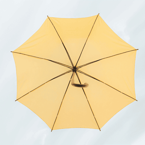 A low-angle view of a bright yellow umbrella against a pale sky, representing an integrated layer of AI for family office software.