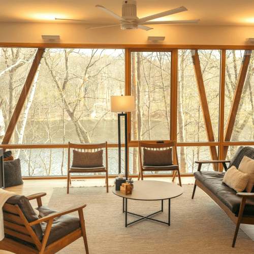 Luxury home living area with a view of trees and water, used to illustrate family office household management.